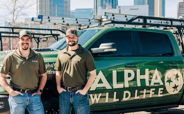 Alpha Wildlife Technicians standing next to their truck